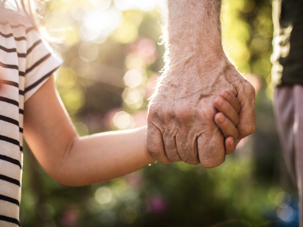 grandfather holding grandchild’s hand